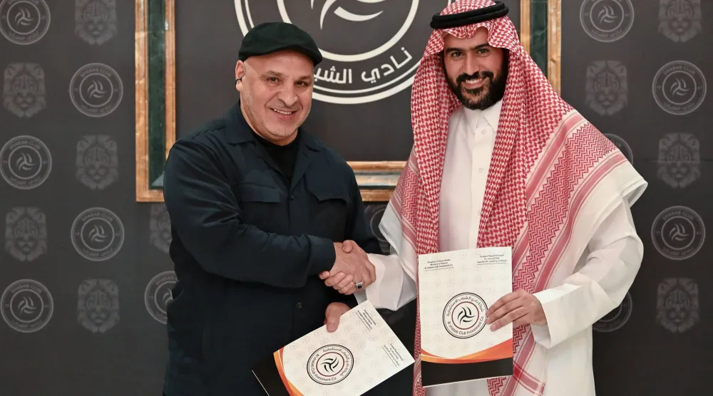 بن زكري يصافح عبد العزيز المالك رئيس الشباب بعد توقيع العقد (موقع النادي)