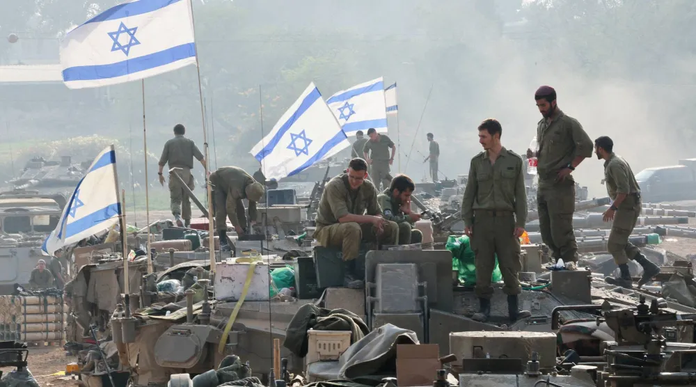 جنود إسرائيليون يقفون على دبابات قرب حدود إسرائيل مع غزة يناير 2024 (رويترز)