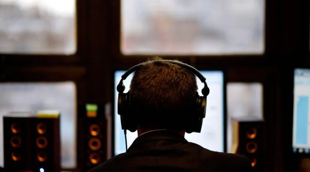 رجل يرتدي سماعات أذن خلال تأدية عمله (رويترز)