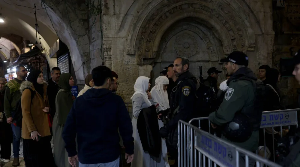 فلسطينيون في أزقة البلدة القديمة بينما تنشر الشرطة الإسرائيلية قوات معززة (إ.ب.أ)