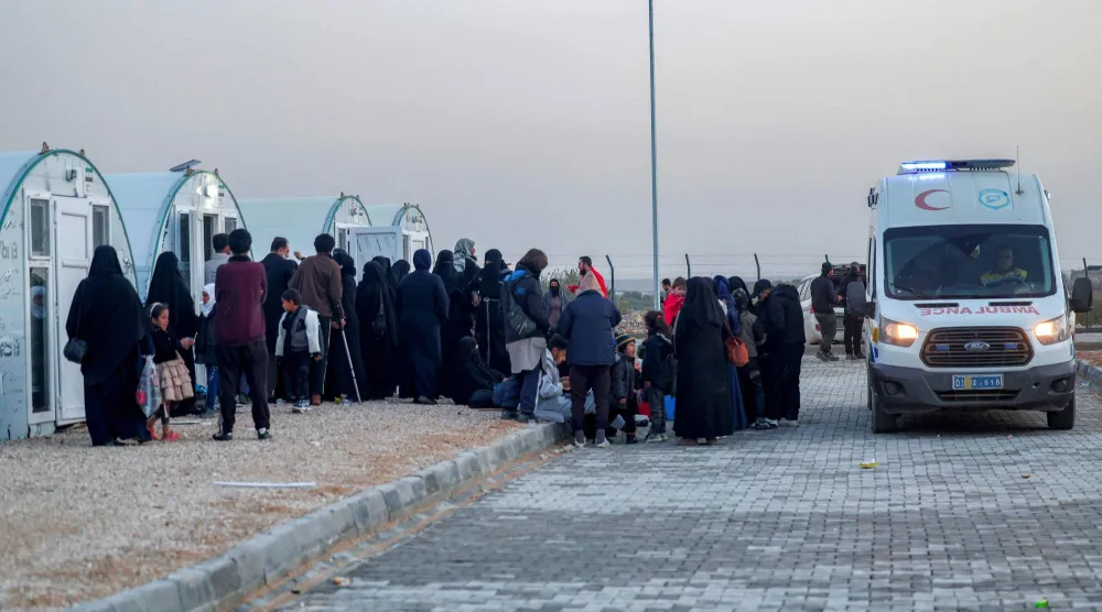 في 17 فبراير ينتظر الوافدون من مخيم الهول شرقي سوريا لتوزيعهم على خيام الإيواء في مخيم «آق برهان» شمال حلب (أ.ف.ب)