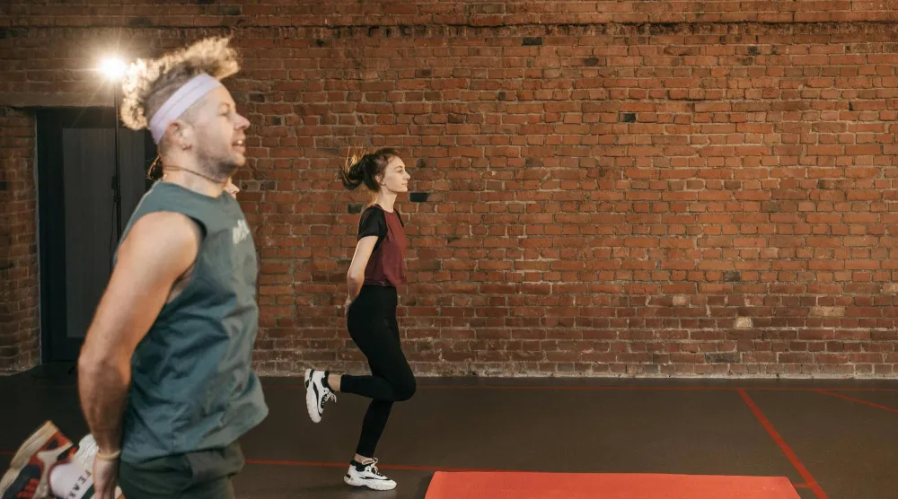 شخصان يمارسان التمارين داخل نادٍ رياضي (بيكسلز)