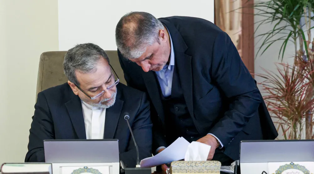 رئيس المنظمة الإيرانية للطاقة الذرية محمد إسلامي ووزير الخارجية عباس عراقجي يراجعان مسودة على هامش اجتماع الحكومة الأربعاء (الرئاسة الإيرانية)