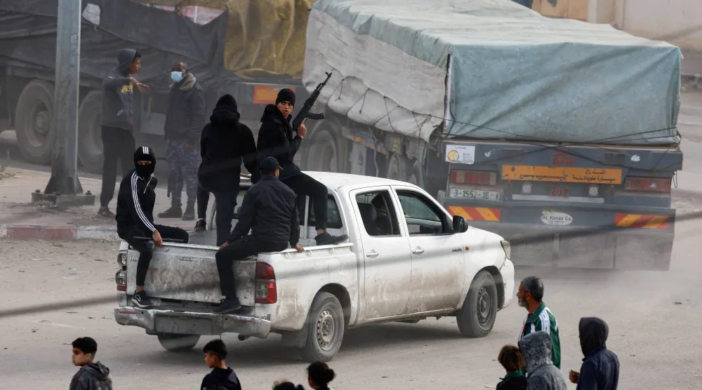 Security personnel guard trucks carrying aid as they arrive in Rafah, amid the ongoing conflict between Israel and the Palestinian Islamist group Hamas, in the southern Gaza Strip January 17, 2024. (Reuters)