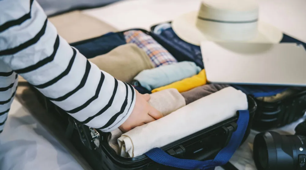 لف الملابس طريقة جيدة لتوضيب حقيبة السفر (شاترستوك)