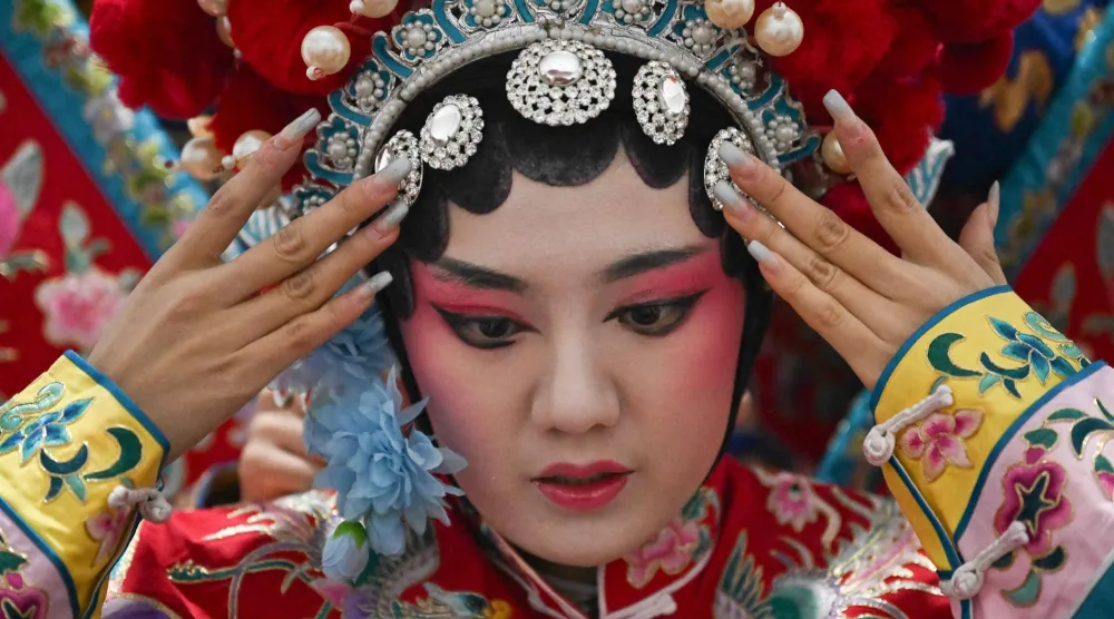 تستعد فنانة أوبرا صينية لتقديم عرض في مهرجان معبد في اليوم الثالث من السنة القمرية في بكين (أ.ف.ب)