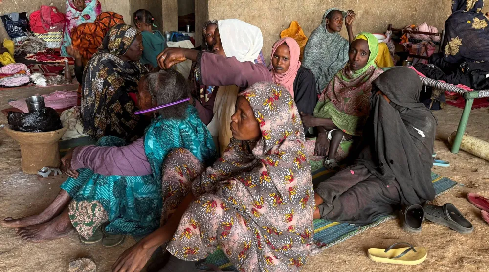 نسوة في مركز تسجيل للنازحين بمدينة الأبيض بولاية شمال كردفان في السودان (رويترز)
