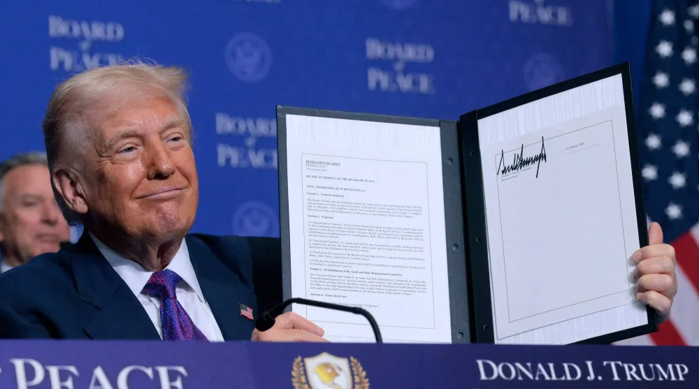 الرئيس الأميركي دونالد ترمب يحمل مذكرة تفاهم وقع عليها خلال اجتماع «مجلس السلام» في واشنطن الخميس (أ.ف.ب) 