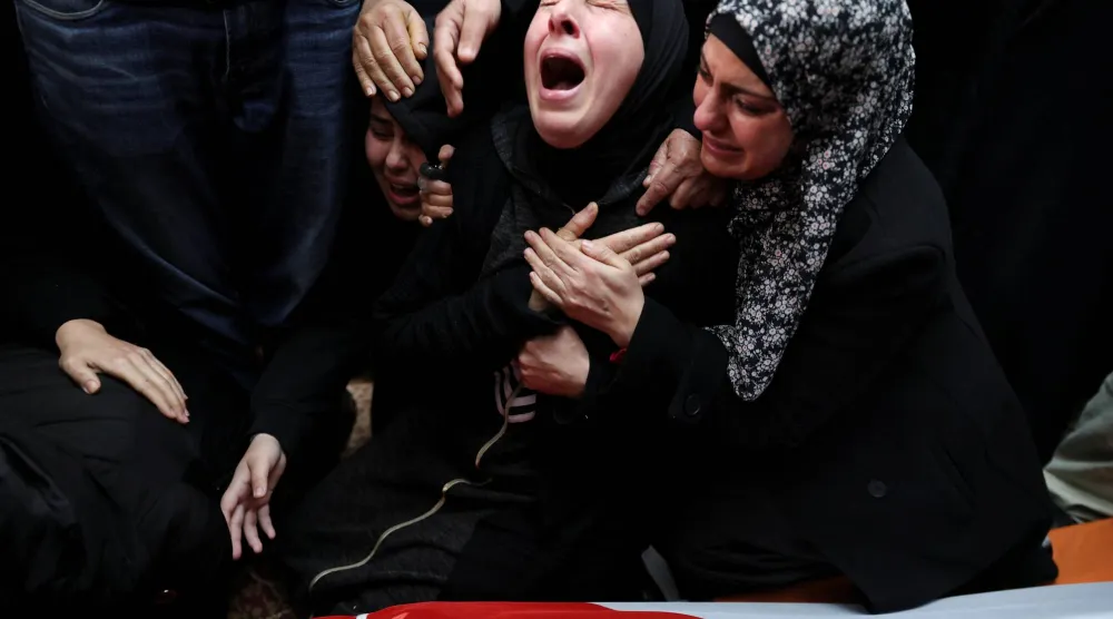 أقارب شاب فلسطيني أميركي قتله مستوطن إسرائيلي في قرية مخماس بالقرب من رام الله بالضفة الغربية المحتلة (رويترز) 