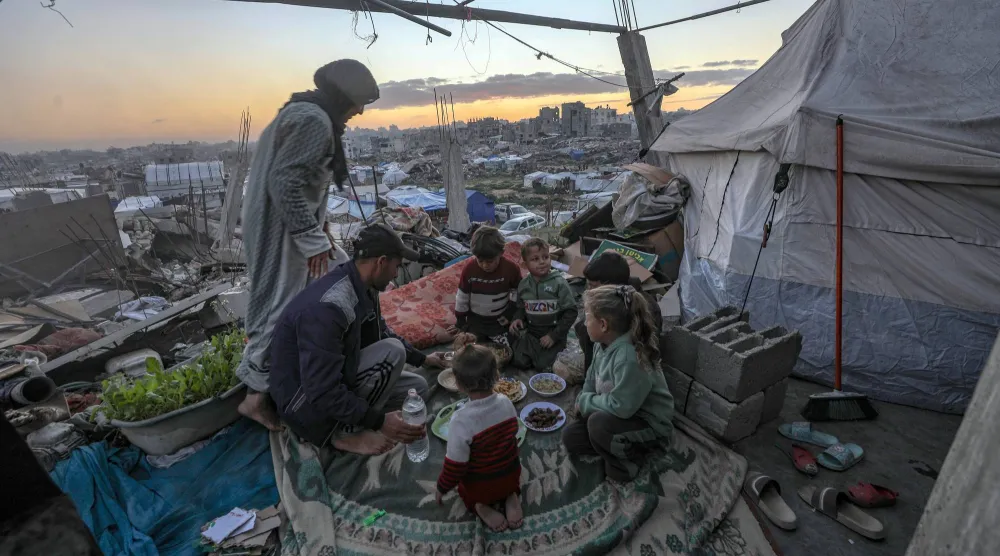عائلة فلسطينية تتناول وجبة الإفطار أمام خيمتهم في جباليا شمال قطاع غزة (إ.ب.أ)