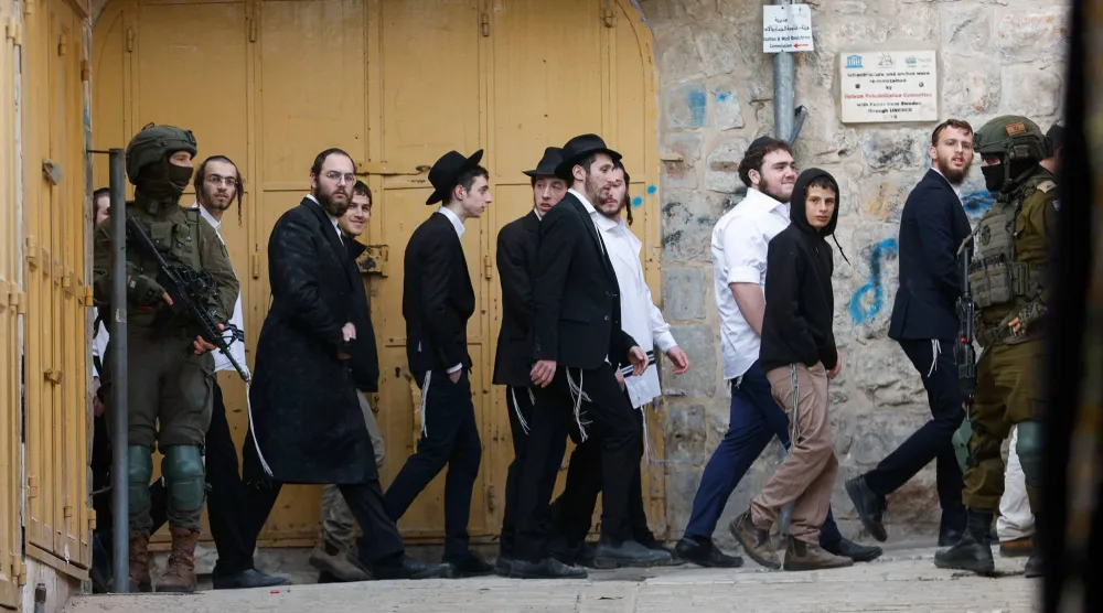 جنود إسرائيليون يقفون في دورية حراسة خلال جولة أسبوعية للمستوطنين الإسرائيليين في الخليل بالضفة الغربية المحتلة 14 فبراير 2026 (رويترز)