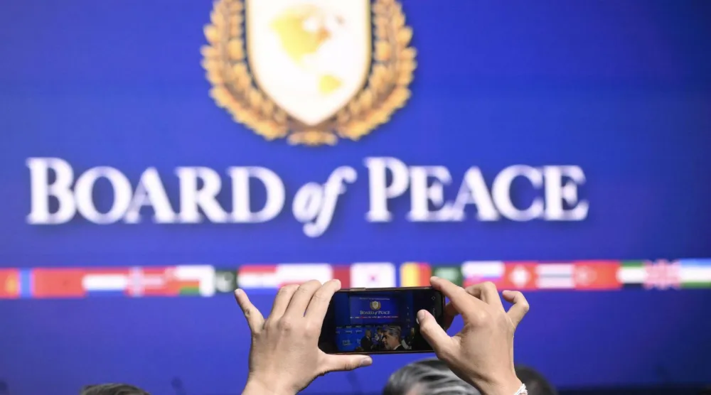 مشارك في اجتماع «مجلس السلام» لغزة يلتقط صورة للشعار خلال أول اجتماعاته في واشنطن الخميس (إ.ب.أ)