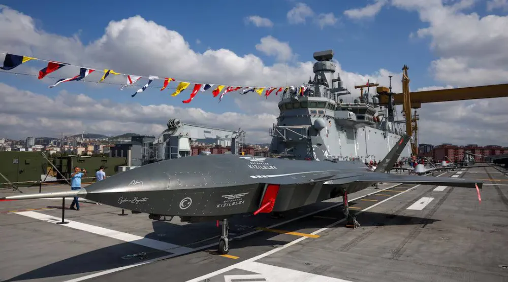 طائرة «كيزيليما» المقاتلة المسيّرة على سطح سفينة «تي سي جي أناضولو» أول سفينة هجومية برمائية تركية إلى جانب طائرات مسيّرة أخرى ومروحيات عسكرية في قيادة حوض بناء السفن البحرية في إسطنبول يوم 29 أغسطس 2025 (رويترز)