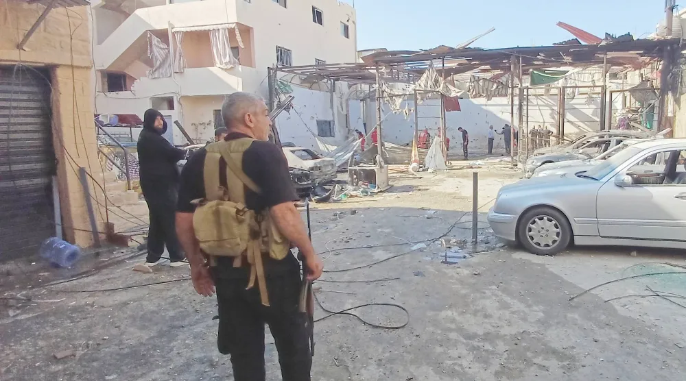 مسلح من «حماس» يقف إلى جانب موقع تعرض لقصف إسرائيلي في مخيم عين الحلوة للاجئين الفلسطينيين بصيدا في شهر نوفمبر الماضي (أ.ب)