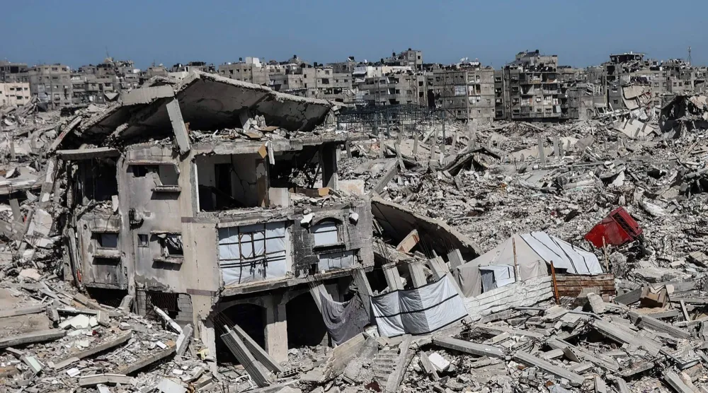 نُصبت خيامٌ تؤوي عائلات فلسطينية نازحة بين أنقاض المنازل والمتاجر التي دمرها الجيش الإسرائيلي في حي الشيخ رضوان بمدينة غزة (أ.ف.ب)