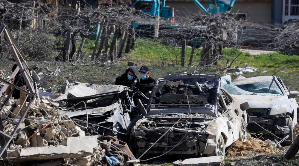 أشخاص يتفقدون الأضرار في موقع الغارة الإسرائيلية على وادي البقاع في شرق لبنان (رويترز)