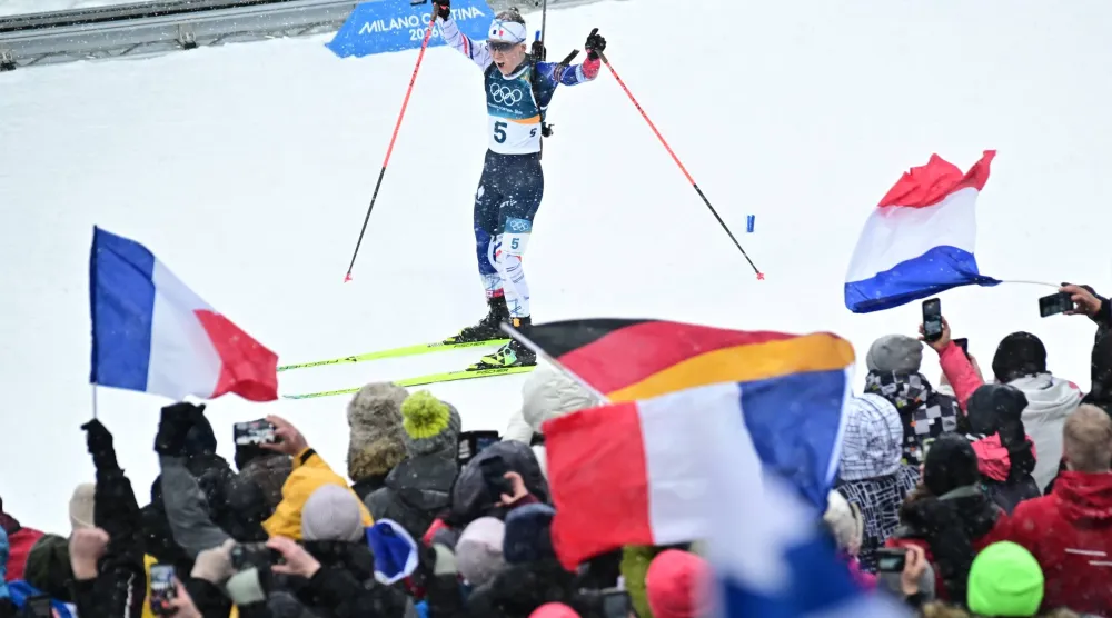 أوسيان ميشلون تحتفل مع الجماهير الفرنسية بذهبية الانطلاق الجماعي (إ.ب.أ)