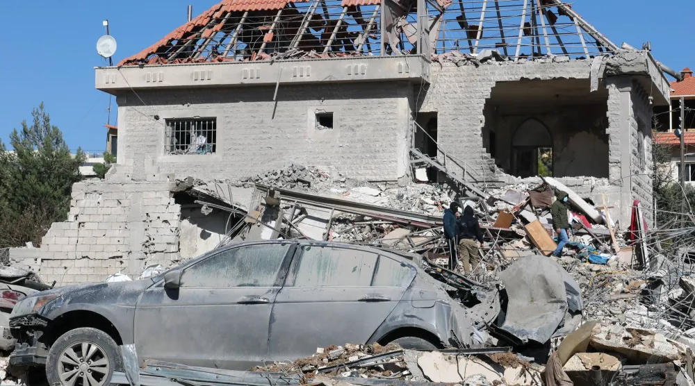 سكان يعاينون أمس الدمار الذي خلفته ضربة إسرائيلية في قرية بدنايل بوادي البقاع شرق لبنان أول من أمس (إ.ب.أ)