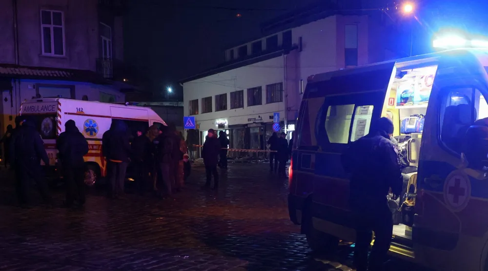 رجال إنقاذ في موقع انفجارات وقعت في وسط مدينة لفيف (رويترز)