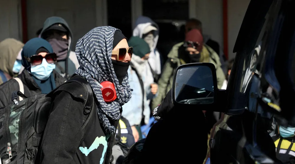 أفراد من عائلات أسترالية يُعتقد ارتباطها بمسلحي تنظيم «داعش» يغادرون مخيم روج قرب ديريك بسوريا في 16 فبراير2026 (رويترز)