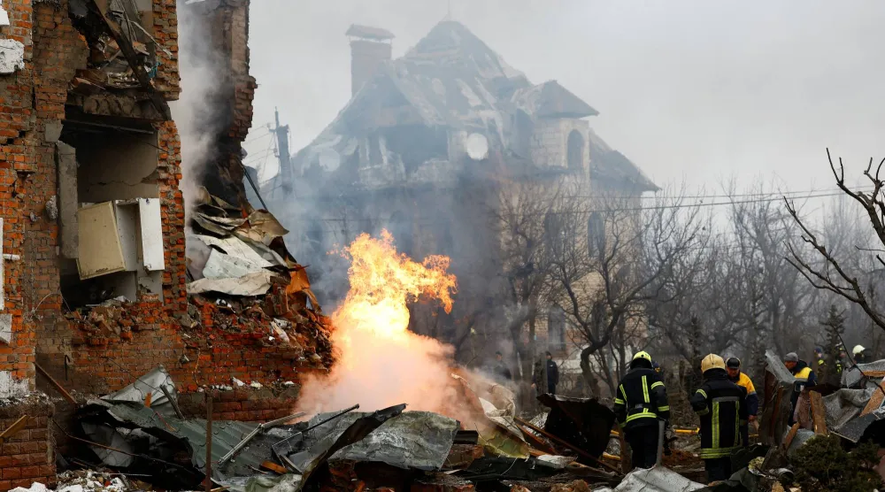 رجال إطفاء أوكرانيون أمام مبنى سكني تضرر جراء الغارات الروسية على كييف (رويترز)