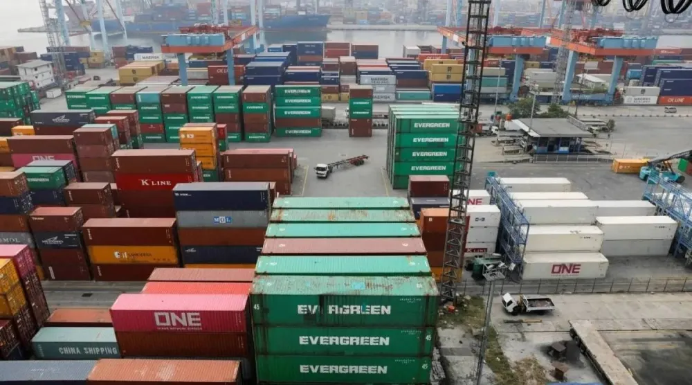 شاحنة تمر بجانب حاويات مكدسة في ميناء تانجونغ بريوك لدى جاكرتا (رويترز)