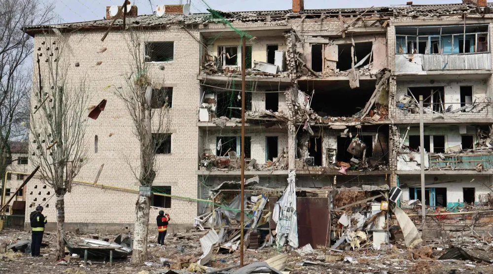 تظهر هذه الصورة التي التقطها ونشرها المكتب الصحافي لـ«اللواء الآلي 65» التابع للقوات المسلحة الأوكرانية يوم 20 فبراير 2026 عناصر إنفاذ القانون الأوكرانيين وهم يقفون بين الأنقاض أمام مبنى سكني متضرر عقب غارة جوية في كوميشوفاخا بمنطقة زابوريجيا (أ.ف.ب)