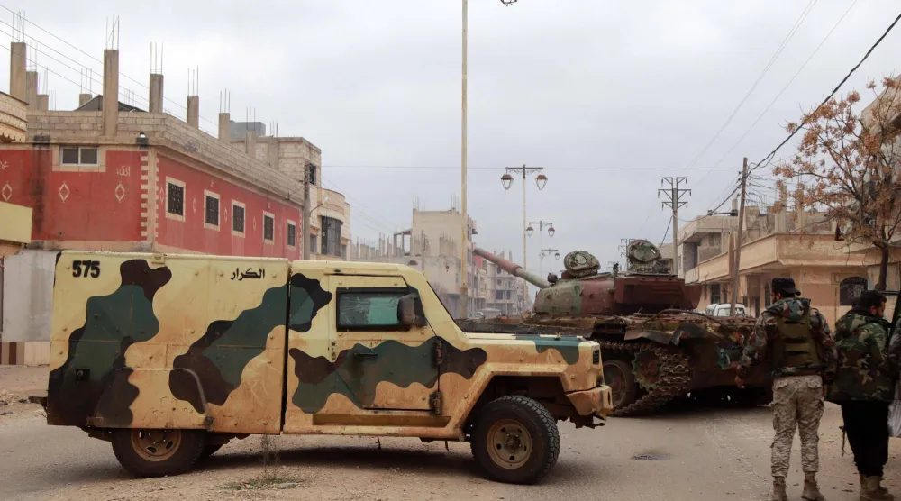 قوات من الجيش السوري تغلق أحد الشوارع في بلدة الصنمين في درعا خلال حملة عسكرية واسعة النطاق لحفظ الأمن الأربعاء والخميس (أ.ف.ب)