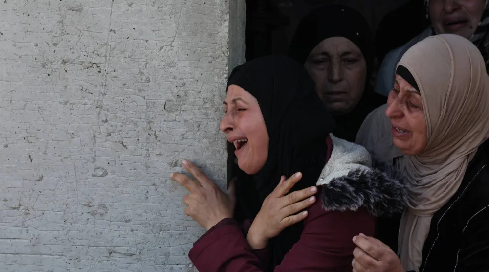 سيدة تبكي خلال تشييع محمد وهبي عبد العزيز حنني (17 عاماً) الذي قُتل بعد إطلاق قوات إسرائيلية النار عليه في بيت فوريك بالضفة الغربية (إ.ب.أ)