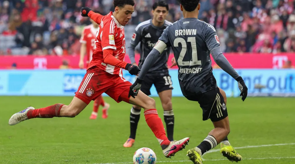 موسيالا يقود هجمة للبايرن وسط مدافعي اينتراخت اول أمس (ا ف ب)