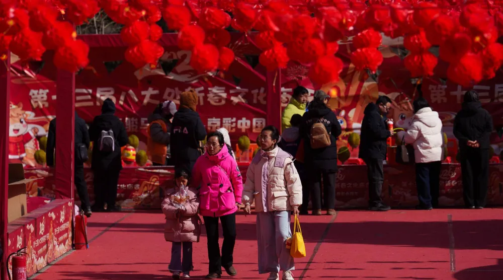 يتجمع الناس تحت زينة الفوانيس الحمراء في حديقة باداشو خلال احتفالات رأس السنة القمرية في بكين (أ.ب)