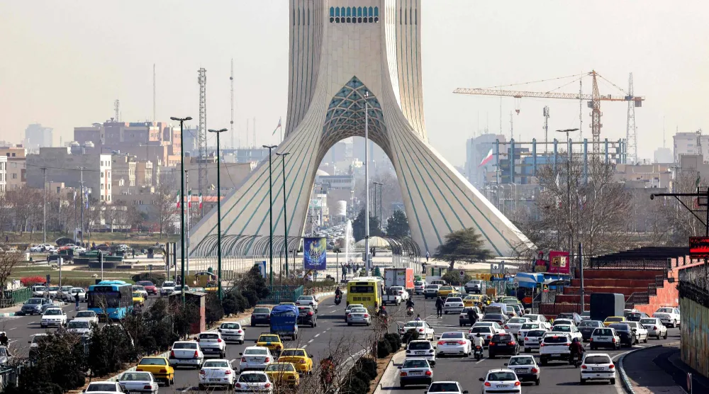Vehicles move along a highway near Tehran's landmark Azadi (Freedom) Tower in Tehran on February 23, 2026. (Photo by ATTA KENARE / AFP)