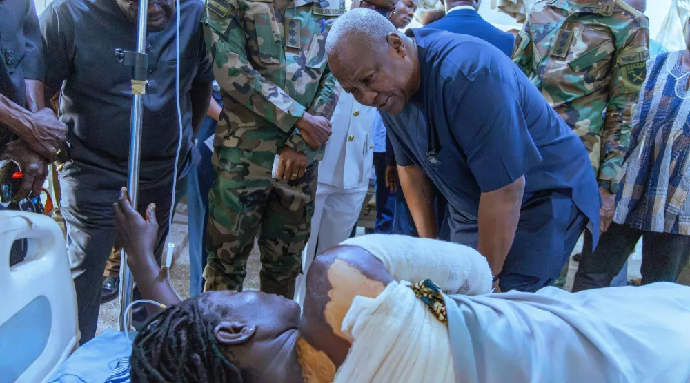 الرئيس الغاني جون ماهاما لدى زيارته أحد مواطنيه المصابين في الهجوم الذي شنه متشددون بشمال بوركينا فاسو الأسبوع الماضي (رويترز)