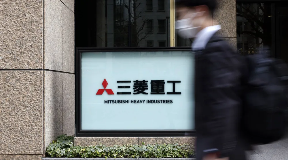 رجل يمر أمام مقر شركة «ميتسوبيشي» للصناعات الثقيلة في العاصمة اليابانية طوكيو (إ.ب.أ)