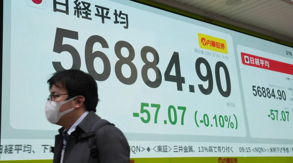 رجل يمر أمام شاشة تعرض حركة الأسهم في وسط العاصمة اليابانية طوكيو (أ.ب)