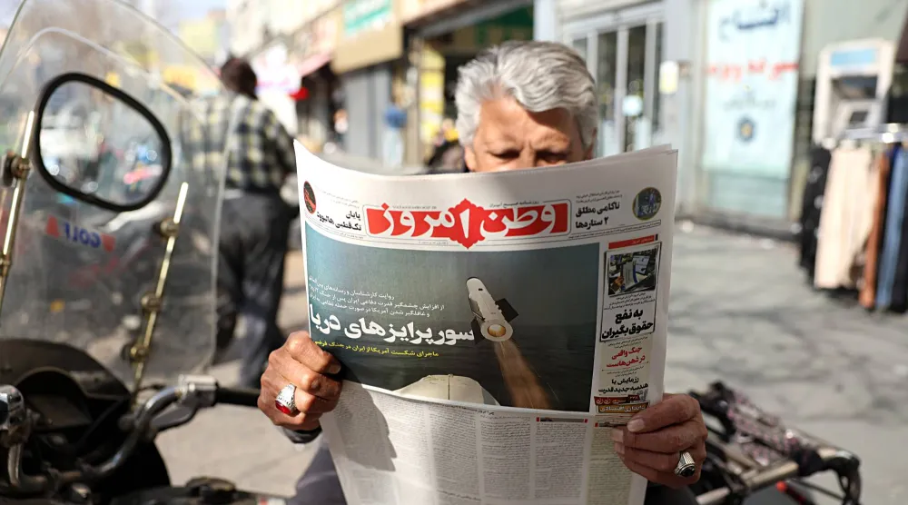 إيراني يمسك بيده صحيفة «وطن أمروز» المقربة من «الحرس الثوري» ويظهر صورة صاروخ على غلافها تحت عنوان «المفاجآت البحرية في طهران 19 فبراير الحالي (إ.ب.أ)