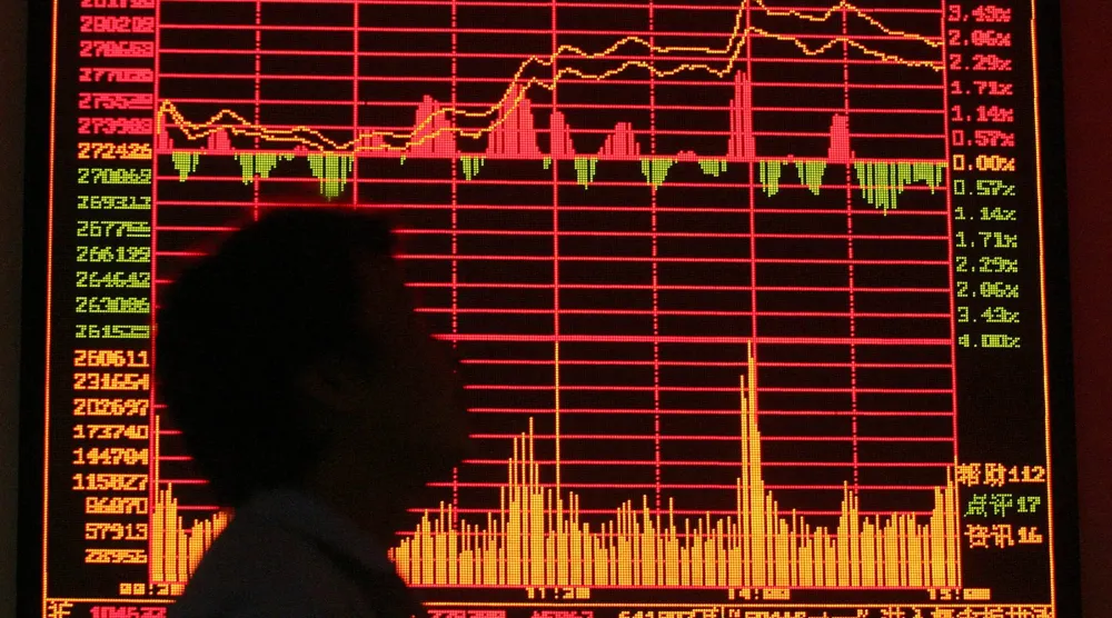 رجل ينظر إلى شاشة تداول في مقر البورصة بمدينة شنغهاي الصينية (رويترز)