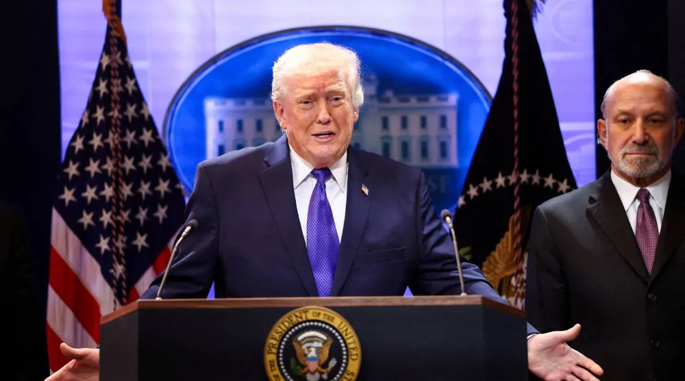 ترمب محاطاً بوزير التجارة هوارد لوتنيك يتحدث خلال مؤتمر صحافي في البيت الأبيض عقب قرار المحكمة العليا (رويترز)