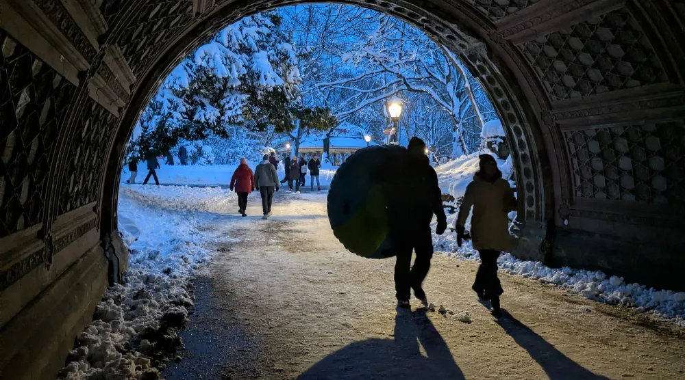 مارة يعبرون تحت جسر قديم في بروكلين بنيويورك بعد عاصفة ثلجية (أ.ب)