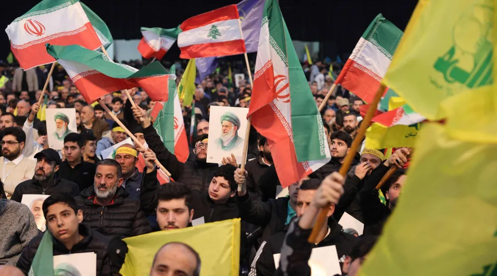 مناصرون لـ«حزب الله» يرفعون أعلام إيران و«حزب الله» في تجمع داعم لإيران دعا له الحزب يناير الماضي (أ.ف.ب)