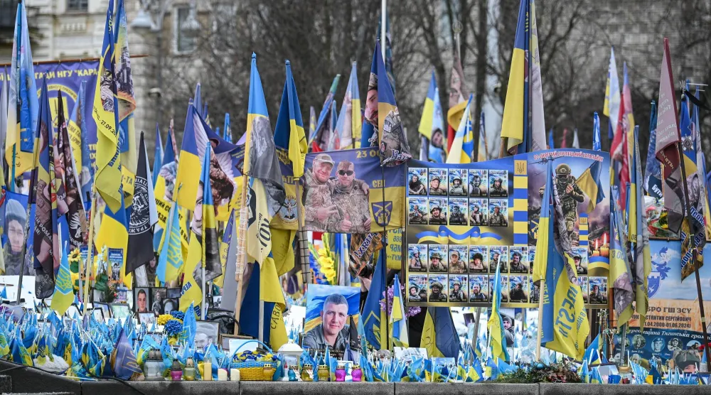 صور وأعلام تظهر ضمن نصب تذكاري للجنود الأوكرانيين الذين سقطوا في ساحة الاستقلال بكييف (إ.ب.أ)