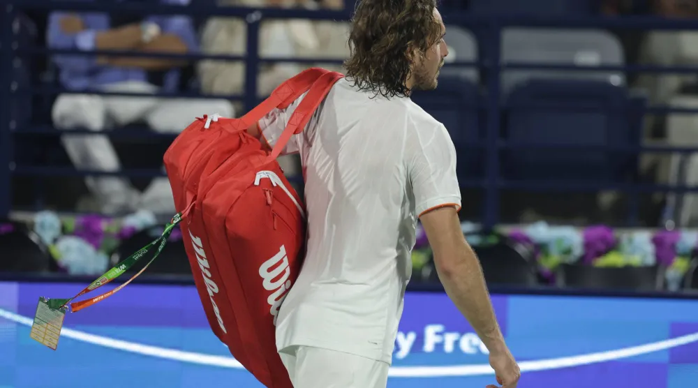 اليوناني ستيفانوس تسيتسيباس يغادر الملعب حزيناً بعد هزيمته في دبي (إ.ب.أ)