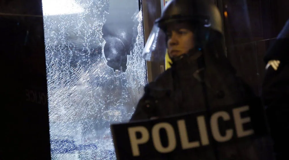 شرطي يقف أمام متجر متضرر خلال احتجاجات بولاية ميسوري عام 2014 (رويترز) 