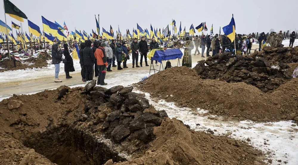 أقارب وزملاء عسكريون لدى حضورهم جنازة جنود أوكرانيين قضوا في الحرب بمدينة خاركيف أمس (إ.ب.أ)