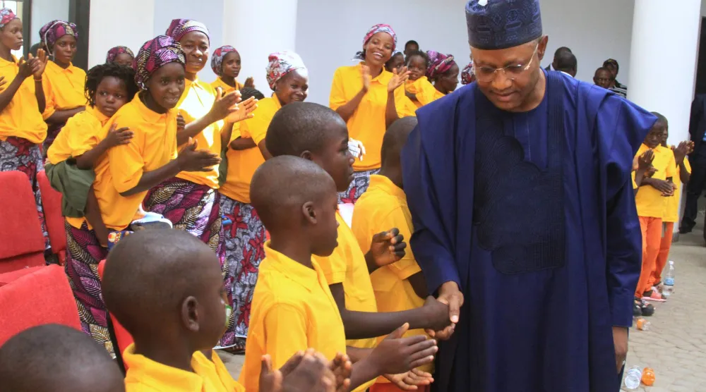 أوبا ساني حاكم ولاية كادونا يصافح رعايا كنيسة اختُطفوا سابقاً من قِبل مجموعات مسلحة بعد عودتهم (أ.ب)