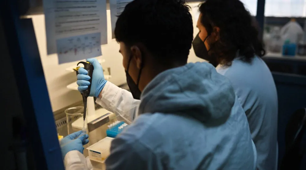 علماء يعملون في مختبرات تابعة لجامعة تشيلي في سانتياغو (أ.ف.ب)