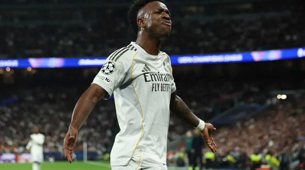 فينيسيوس يحتفل بعد مساهمته في هدف الريال الأول (رويترز)