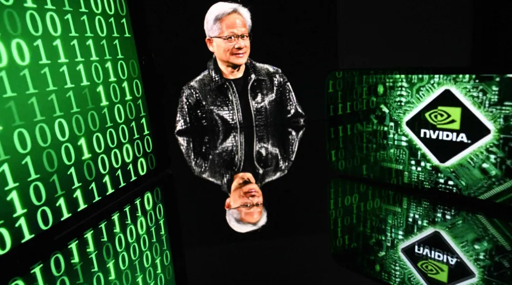 شاشات تعرض صورة رئيس «إنفيديا» جينسين هوانغ وشعار الشركة في تولوز (أ.ف.ب)