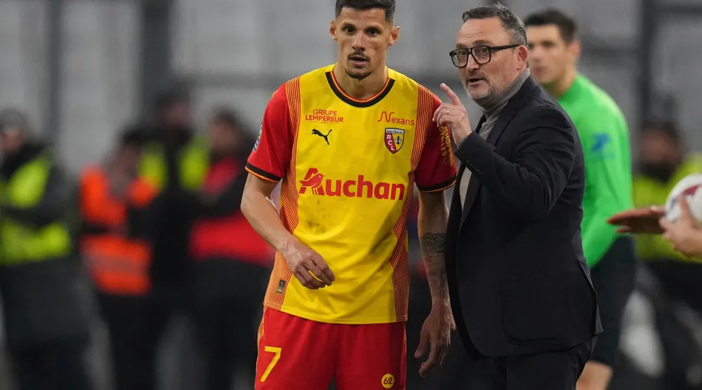 FILE - Lens' head coach Franck Haise talks to Lens' Florian Sotoca during a French League One soccer match between Marseille and Lens at the Stade Velodrome stadium in Marseille, France, Sunday, April 28, 2024. (AP Photo/Daniel Cole. file)