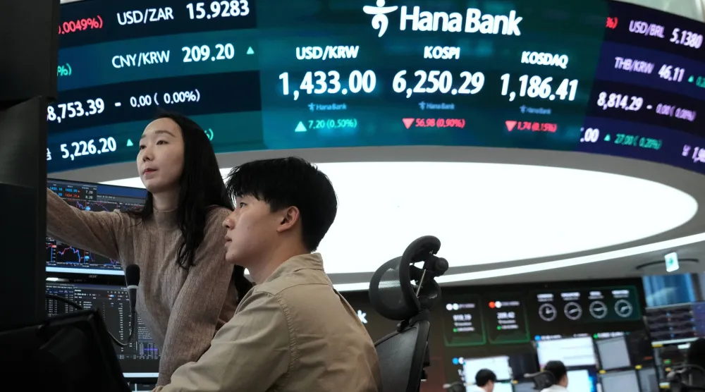 متداولو عملات يراقبون مؤشر «كوسبي» وسعر صرف الدولار مقابل الوون داخل قاعة تداول في بنك هانا بسيول (أ.ب)